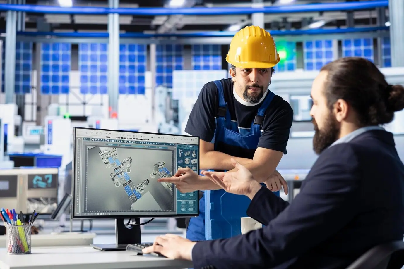 Ingenieure eines Solarpanel-Werks sprechen und brainstormen über Möglichkeiten zur Effizienzoptimierung.